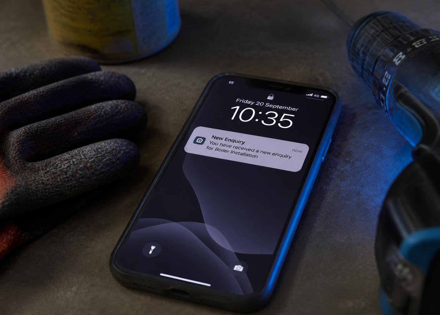A phone on a workbench showing a new media wall enquiry notification